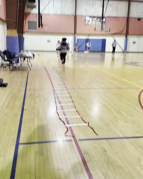 Players walking past the agility ladder between drills
